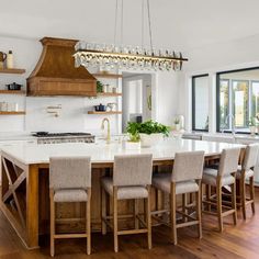 a large kitchen with a center island surrounded by chairs