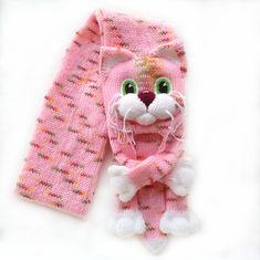 a pink knitted cat scarf and leggings on a white background, with green eyes