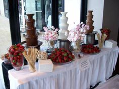 a table topped with lots of chocolate covered desserts and strawberries on top of it