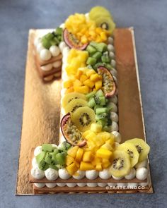 there is a cake decorated with fruit on the table