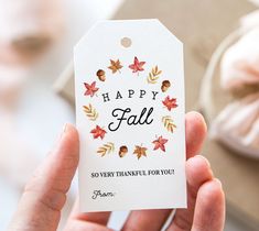 a person holding a happy fall tag in their hand