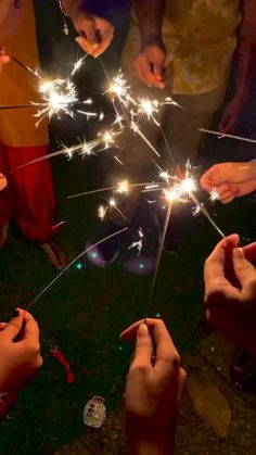 several people holding sparklers in their hands