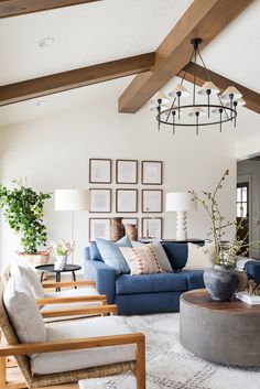 a living room with couches, chairs and pictures hanging on the wall above them