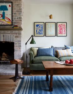 a living room filled with furniture and a fire place in front of a brick fireplace