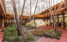 a house in the woods with steps leading up to it's entrance and trees