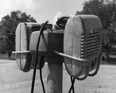 an old fashioned phone is attached to a pole with two wires in the middle of it