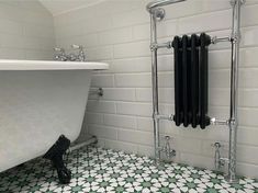 a white bath tub sitting next to a wall mounted radiator