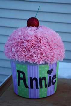 a cupcake with pink frosting and a cherry on top that says, annie