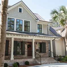 a white house with black shutters and palm trees