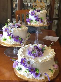 two wedding cakes with purple and white flowers on them