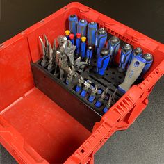 a red tool box filled with tools on top of a table