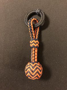 an orange and blue lanyard with a knot on the end that is attached to it