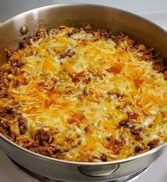 a large skillet filled with cheese and meat