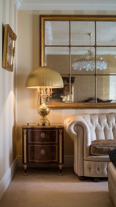 a living room with a couch, lamp and mirror on the wall next to it