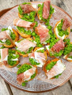 a platter filled with lots of different types of food on top of a wooden table