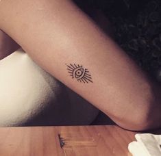 a woman's arm with a small sun tattoo on the left side of her arm