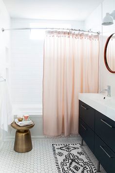 a white bathroom with black and gold accents