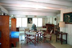 a dining room table and chairs in front of a book shelf with books on it