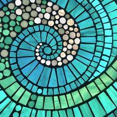 a close up view of a stained glass window with a spiral design in the center