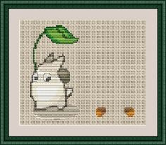 a cross stitch pattern with a cow holding a green leaf