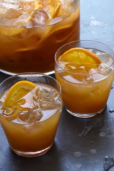 two glasses filled with drinks sitting on top of a table