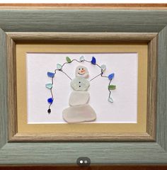 a snowman with blue and white lights on it's head in a frame