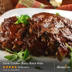 slow cooker baby back ribs on a plate with parsley garnishes