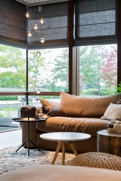 a living room filled with furniture and windows covered in shades on the outside, along with a coffee table