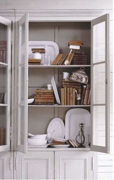 an open bookcase filled with lots of books and other items on top of it