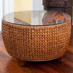 a wicker coffee table sitting on top of a hard wood floor