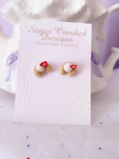 the earrings are on display in front of a card