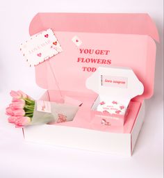 pink tulips are in a white box with the words you get flowers too