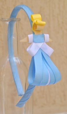 a glass vase with a blue ribbon tied around it and a yellow bow on the top