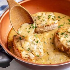 a pan filled with meat covered in gravy and topped with a wooden spoon