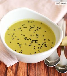 a white bowl filled with soup on top of a wooden table