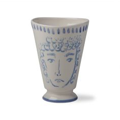 a blue and white vase with a face on it's side, in front of a white background