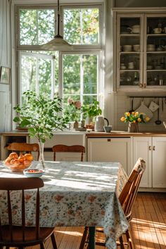 a kitchen with a table, chairs and potted plants in the window sill