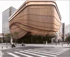 a large wooden building sitting on the side of a street next to tall glass buildings