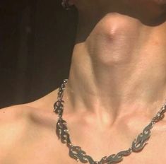 a close up of a man's chest wearing a necklace with links on it