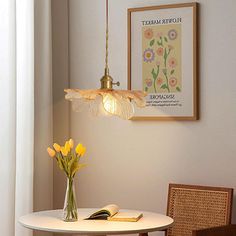 a table and chairs in a room with a lamp on the wall next to it