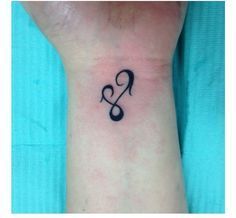 a small musical note tattoo on the wrist