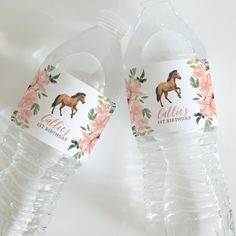 two plastic water bottles with horses and flowers on them, one has a label for each bottle