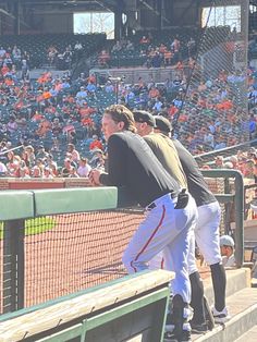 the baseball players are getting ready to bat at the game in front of an audience