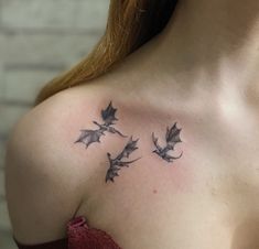 a woman's chest with three flying bats on her left shoulder and the other arm