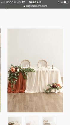 the table is set with two chairs and an arrangement of flowers on top of it