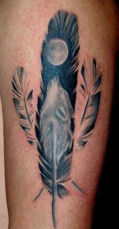 a black and white photo of a feather tattoo