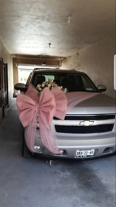 a silver truck with a pink bow tied to it