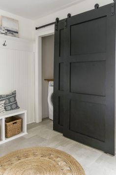 an open door leading to a washer and dryer in a room with white walls