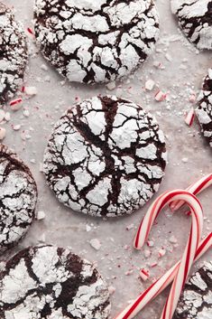 cookies and candy canes on a table with powdered sugar, peppermint sticks and candies