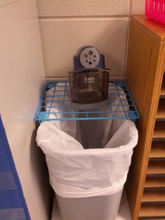 a trash can sitting on top of a metal shelf